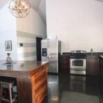 Open-concept kitchen with modern appliances in La Fortuna Costa Rica Spanish Colonial home la fortuna costa rica real estate agent arenal volcano hot springs income property airbnb