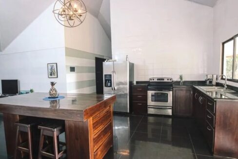 Open-concept kitchen with modern appliances in La Fortuna Costa Rica Spanish Colonial home la fortuna costa rica real estate agent arenal volcano hot springs income property airbnb