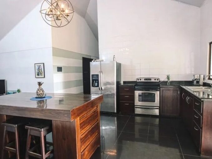 Open-concept kitchen with modern appliances in La Fortuna Costa Rica Spanish Colonial home la fortuna costa rica real estate agent arenal volcano hot springs income property airbnb