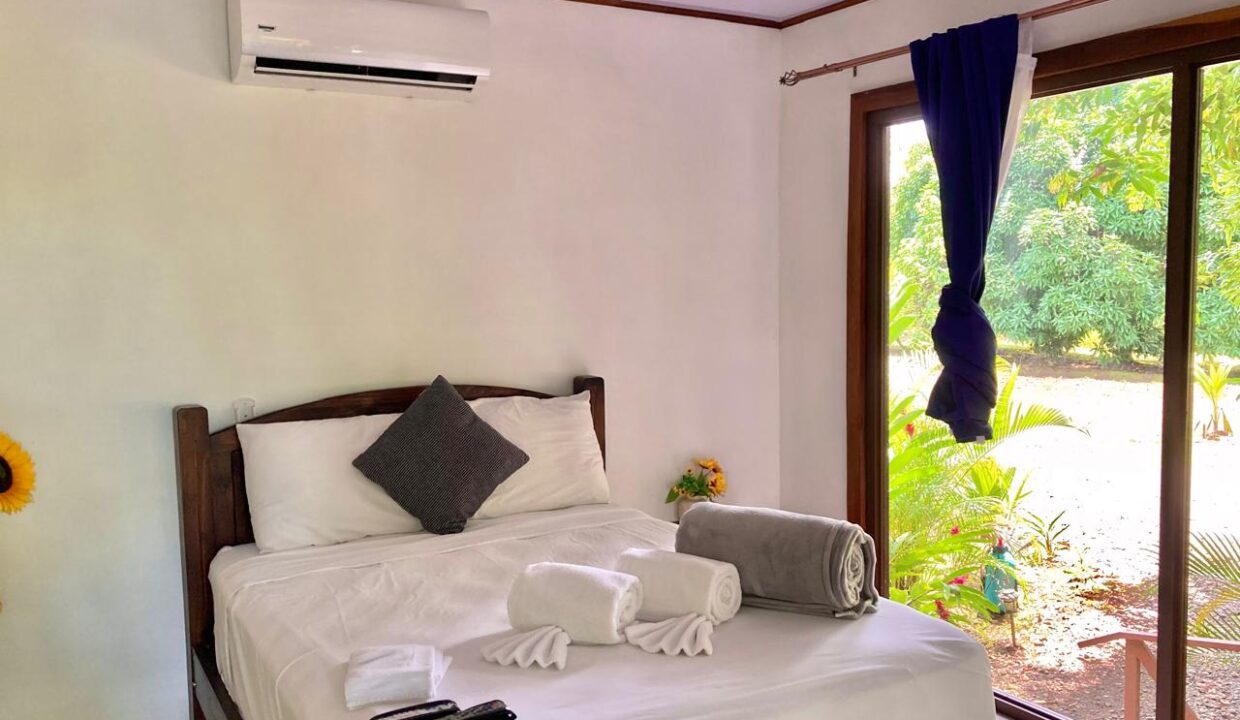 Cozy Cabin Bedroom with Queen Bed and Large Windows Featuring Arenal Volcano View in Chachagua, La Fortuna Costa Rica