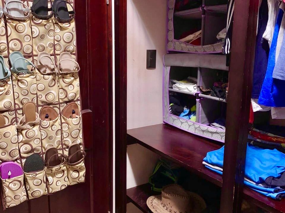 Compact shoe rack and wall organizer within closet area of La Fortuna home for sale