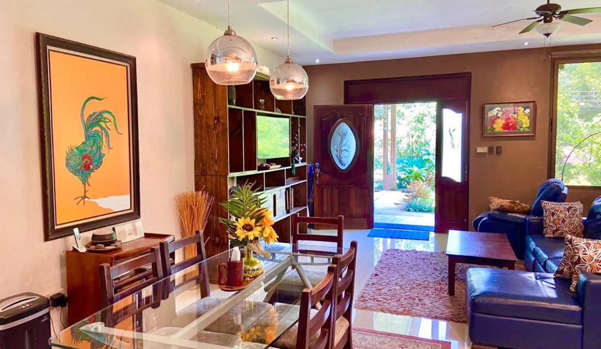 Dining area with bright artwork and garden entrance – La Fortuna Costa Rica Real Estate