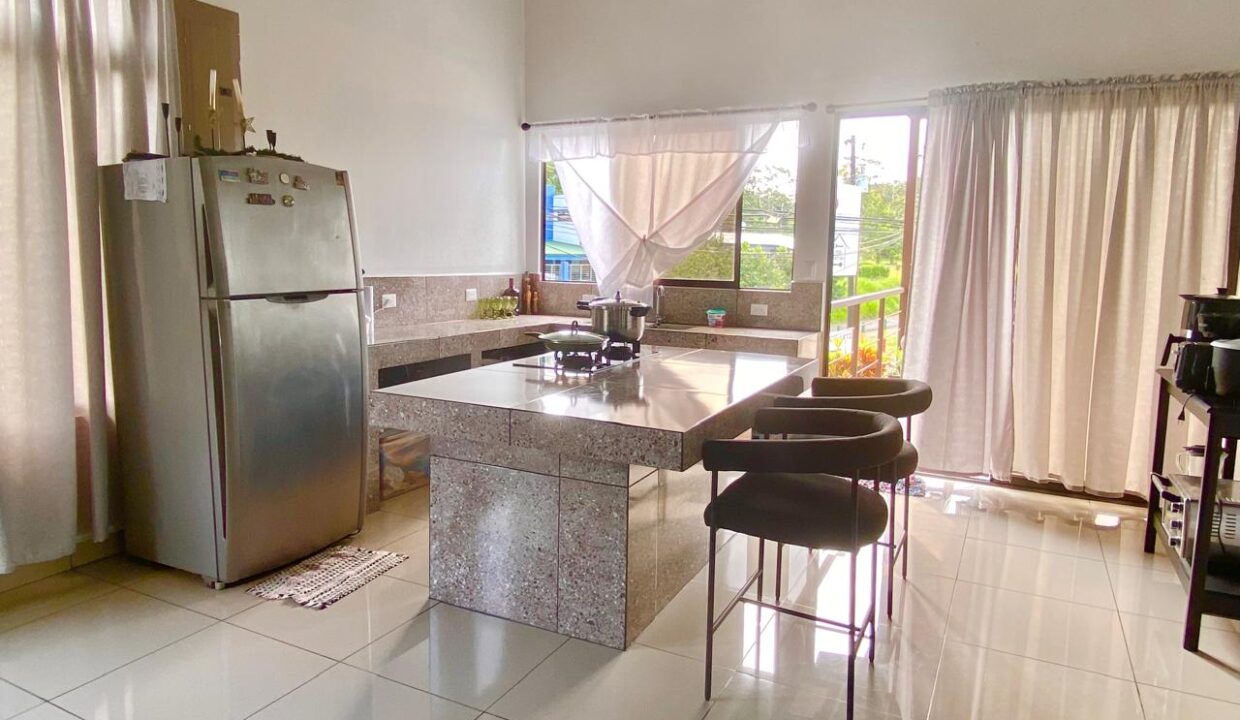 Modern kitchen with granite counters, upscale fridge, and access to volcano-view terrace in La Fortuna