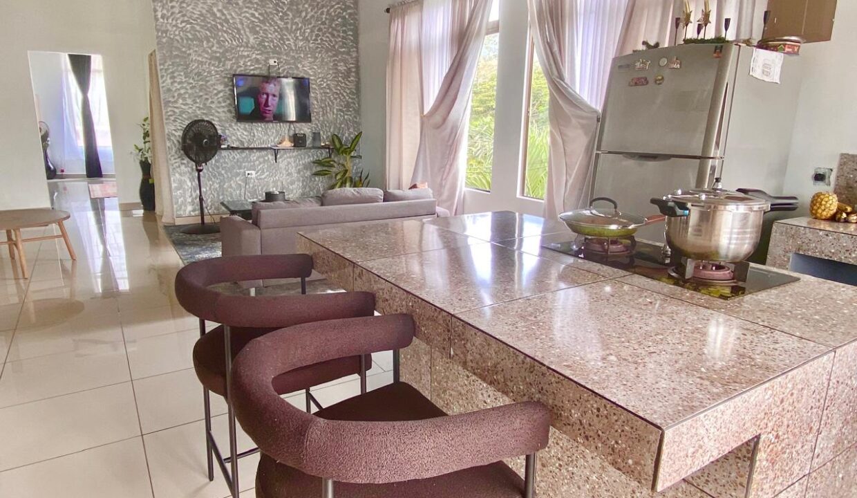 Stainless kitchen and granite island with bar seating in La Fortuna penthouse