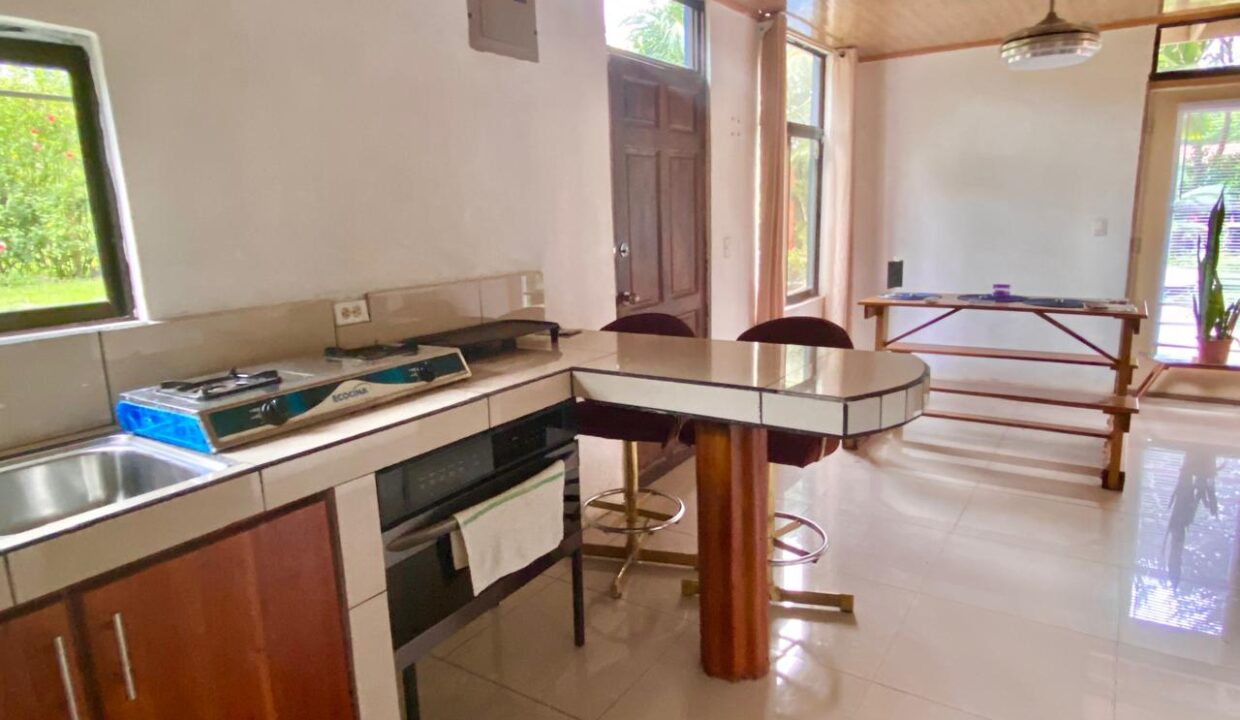 Modern tile countertops, island seating and bright windows in Costa Rica real estate near La Fortuna