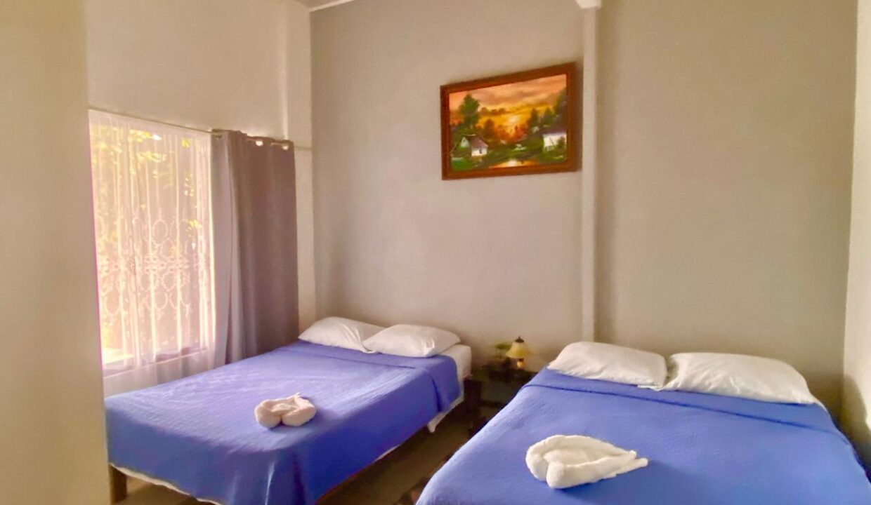 Spacious bedroom with twin double beds in La Fortuna Airbnb apartment near Arenal Volcano