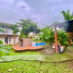 overview of duplex, pool with waterfall, and BBQ rancho under palm trees