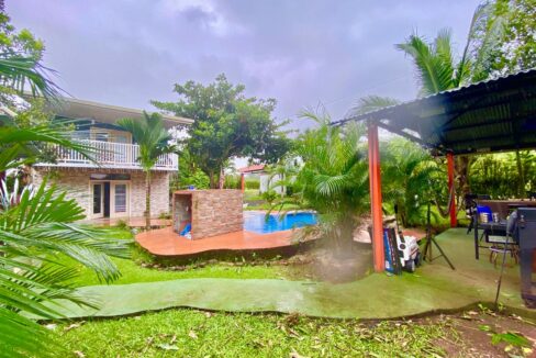 overview of duplex, pool with waterfall, and BBQ rancho under palm trees