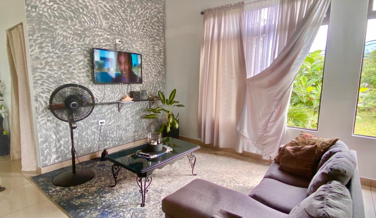 Modern furnished living area with TV and plants in La Fortuna rental home