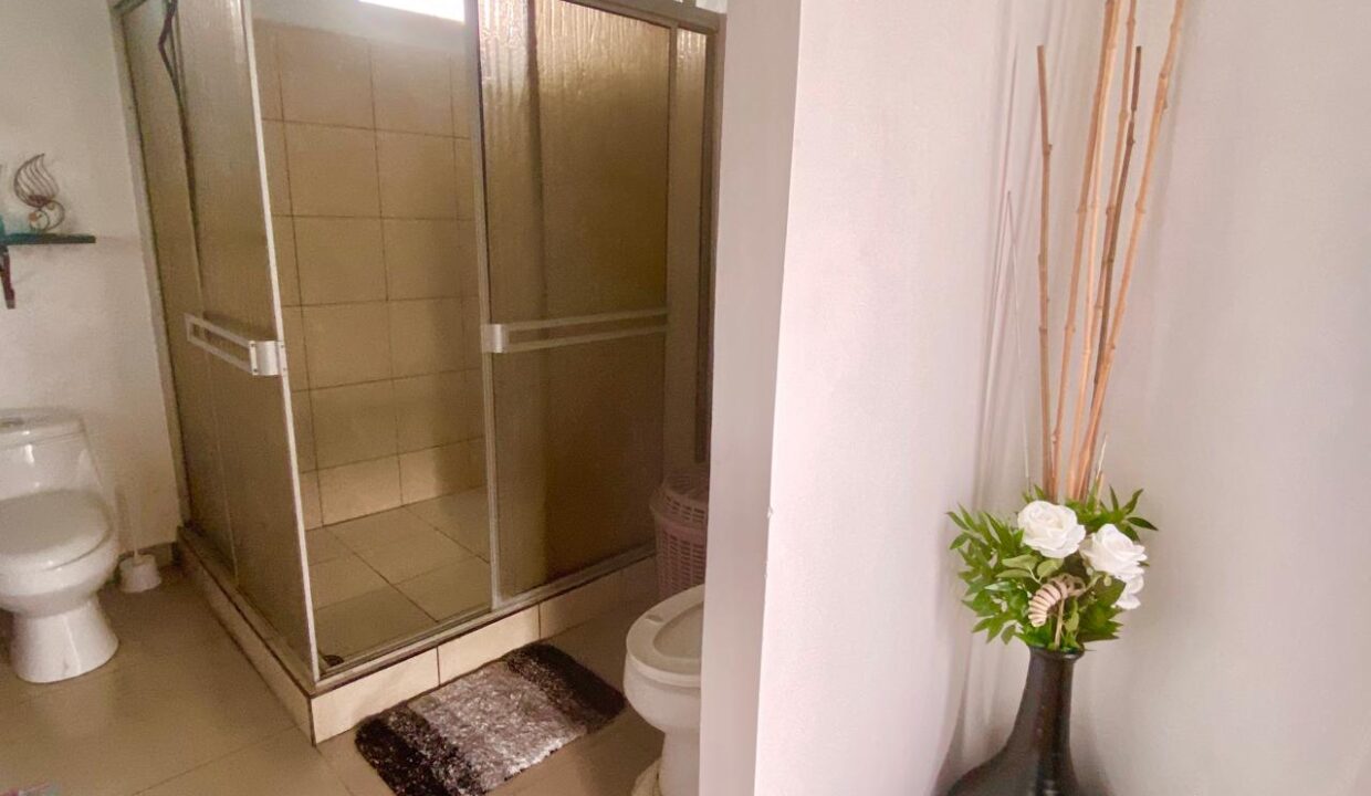 Penthouse-level bathroom with walk-in shower, sink, and storage in La Fortuna rental property