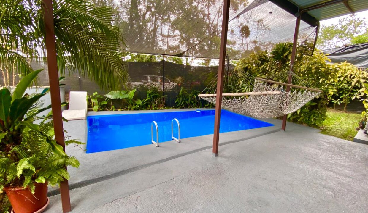 Relaxing pool area with greenery and hammock in La Fortuna Airbnb investment property