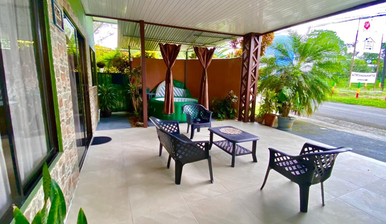 Outdoor patio with sitting area and garden view in La Fortuna Airbnb property