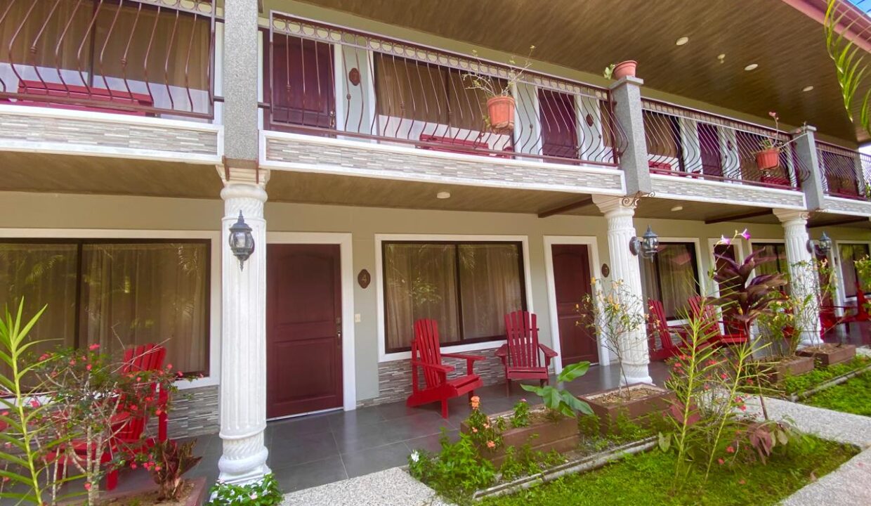 Hotel upper-level patio with red wooden chairs in La Fortuna, Costa Rica