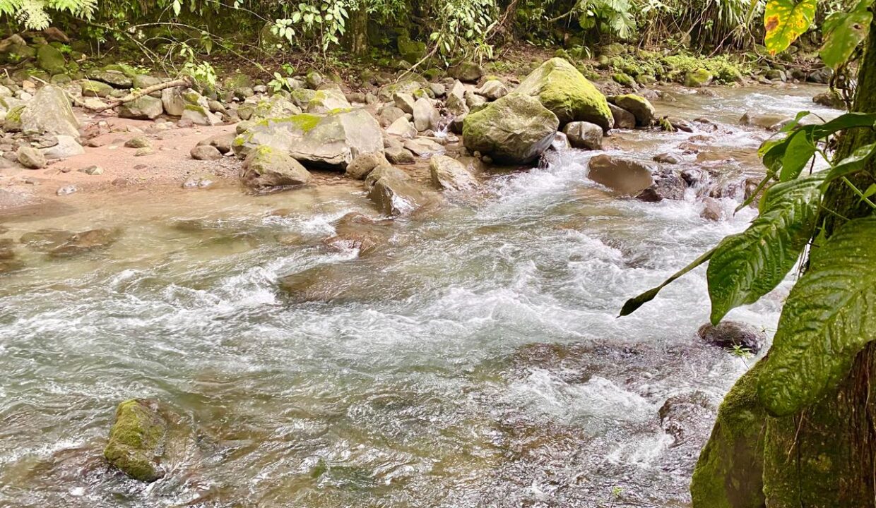 La Fortuna riverfront property with crystal-clear water and rocks, ideal for eco-tourism development