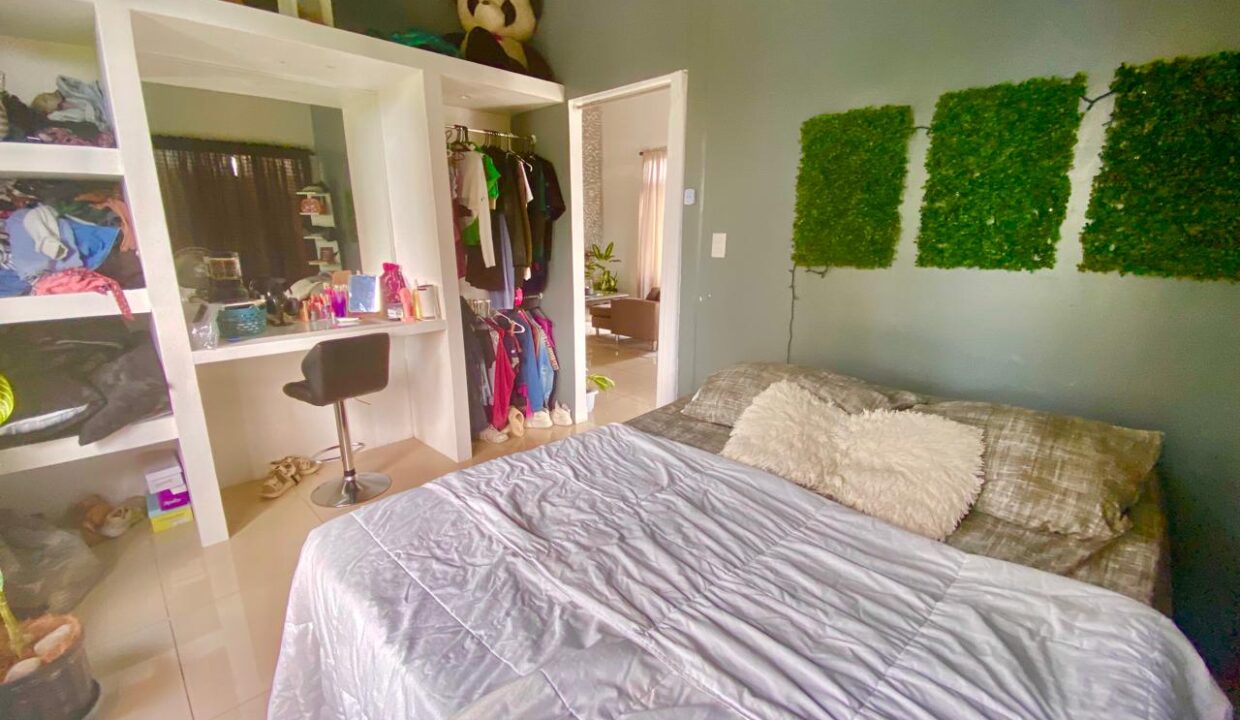 Spacious guest bedroom with built-in shelving and large closet in La Fortuna penthouse