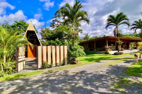 Tropical Glow entrance with A-frame guest cabin and lush gardens in La Fortuna Costa Rica