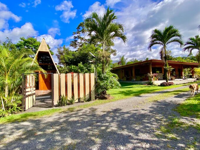 Tropical Glow entrance with A-frame guest cabin and lush gardens in La Fortuna Costa Rica