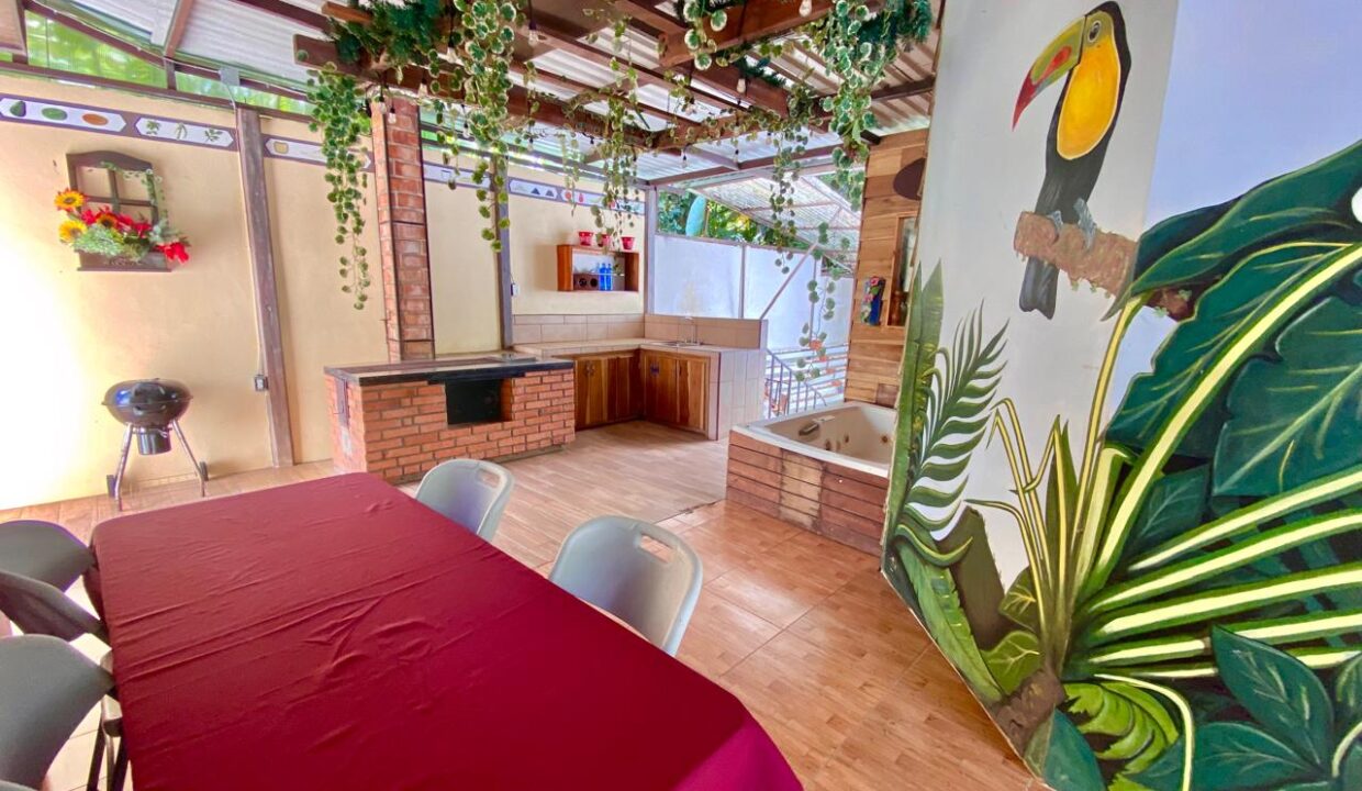 Vibrant covered patio with barbecue and spa tub in Jauuri rental property