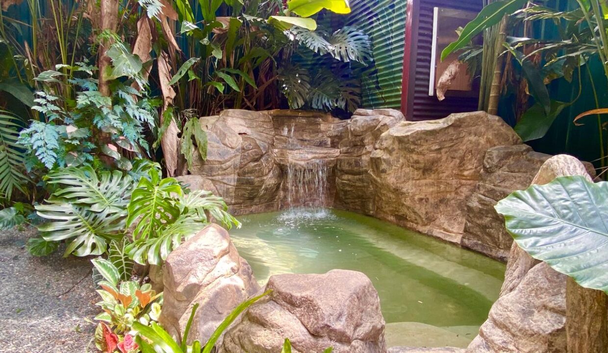 Stone waterfall jacuzzi in tropical garden at Jauuri income property