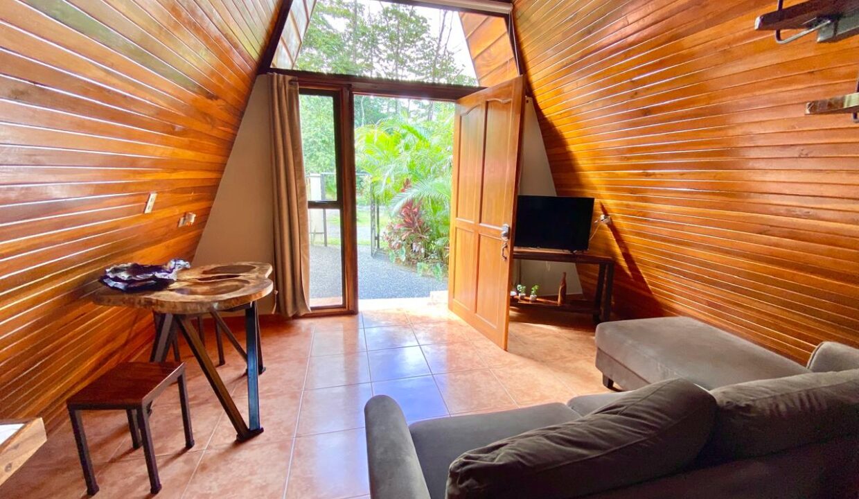 Tropical guest cabin interior with lounge and desk space near Arenal Volcano