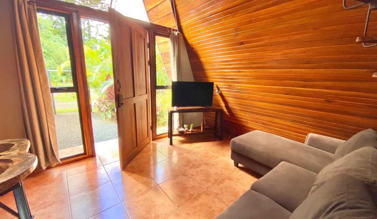 Compact tropical cabin interior with garden access near Arenal Volcano