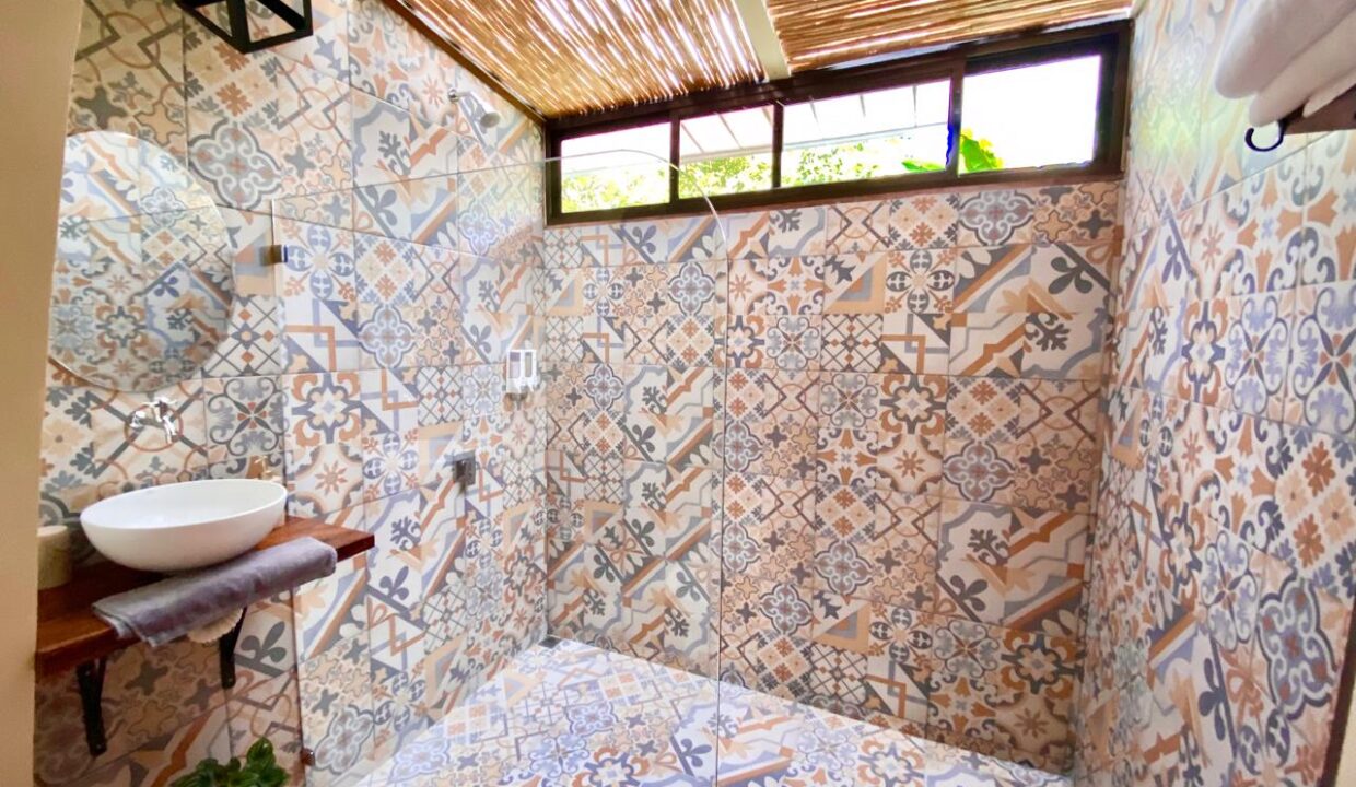 Colorful walk-in shower with patterned ceramic tile near Arenal Volcano