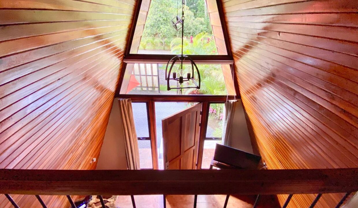 Loft-level perspective over tropical cabin entrance near Arenal Volcano