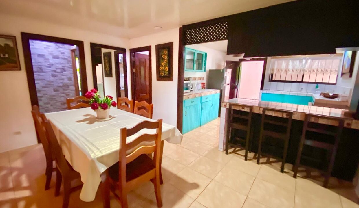 Bright kitchen featuring a gas stove, microwave, dual sink, and open shelving.