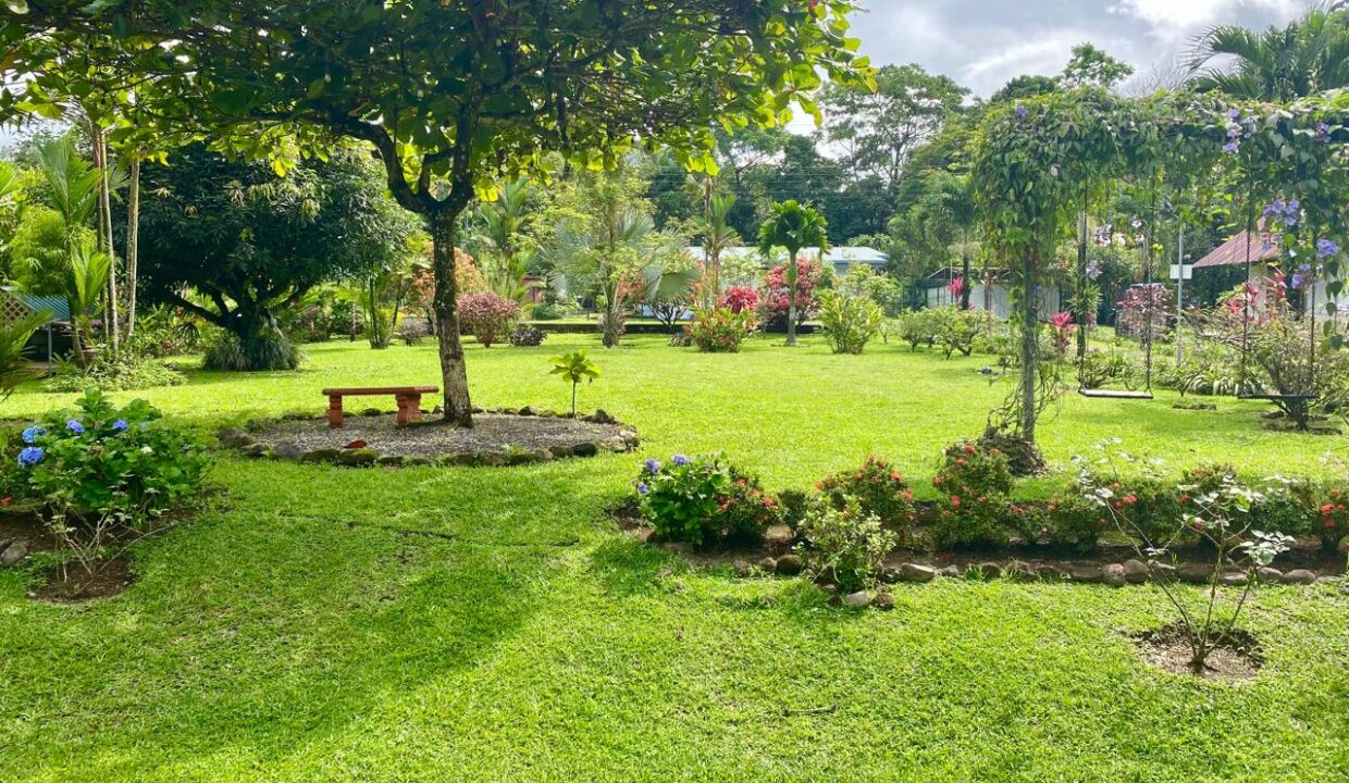 Open garden space with ornamental trees and vibrant flowers near Arenal Volcano