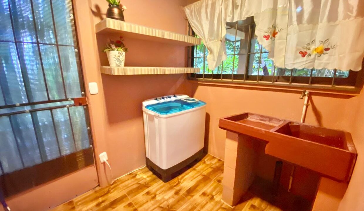 Bright and well-ventilated laundry room featuring open shelving and garden views through the window