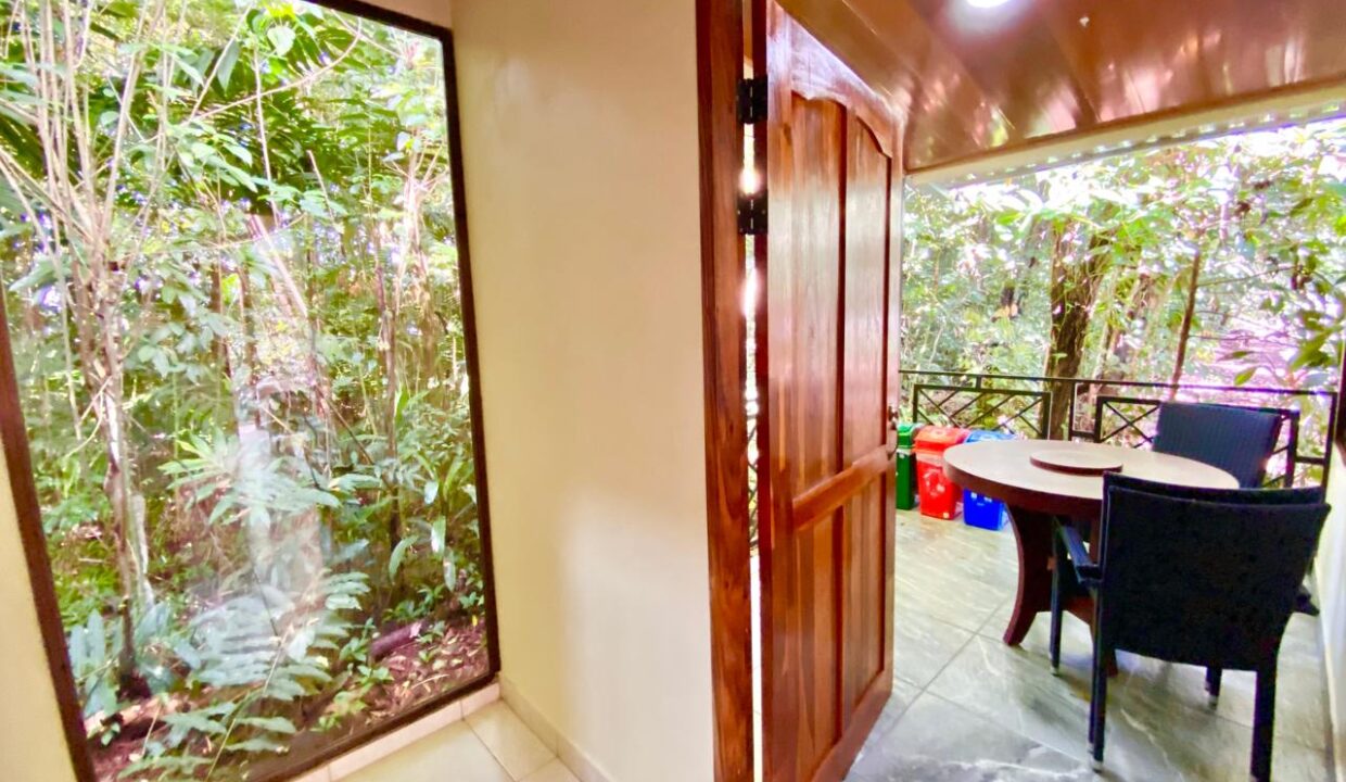 Tropical Glow Costa Rica cabin hallway leading to covered jungle-view patio near Arenal Volcano
