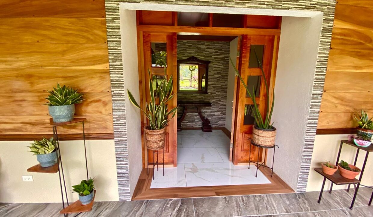 Welcoming entrance with greenery and decorative tile in La Fortuna home