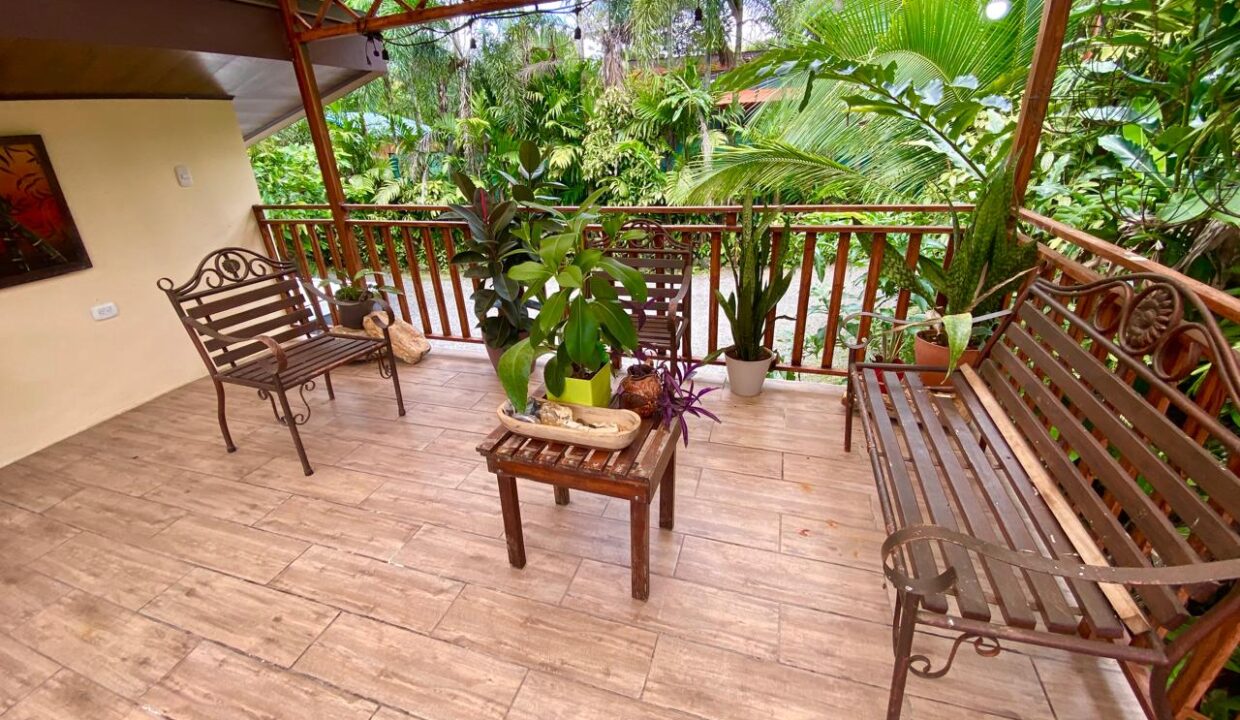 Charming covered balcony with lush tropical foliage in Jauuri rental home