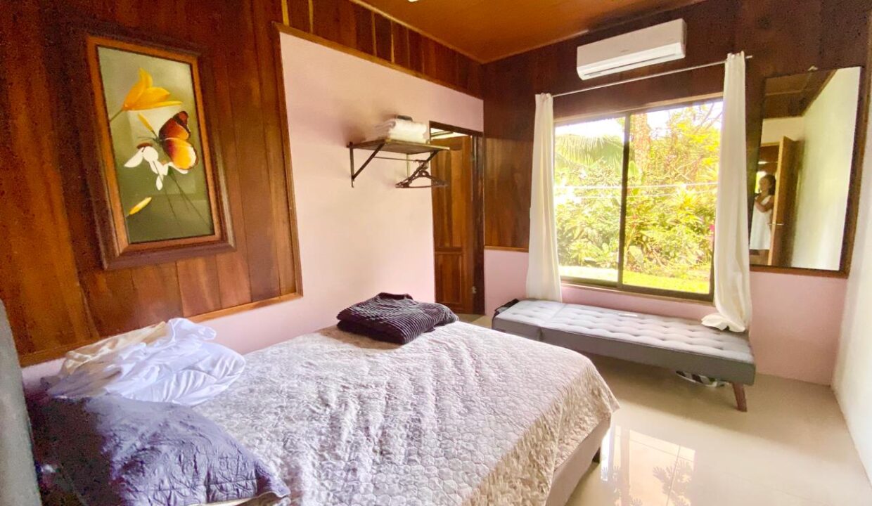 Bright bedroom with natural light and tropical wood walls near Arenal Volcano