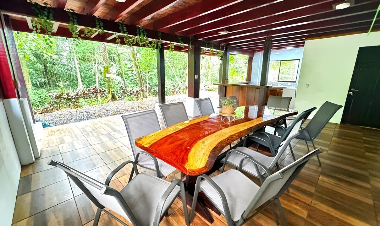 Custom wood dining table in Costa Rica riverfront property for sale. La Fortuna real estate with jungle views and fully furnished interior.