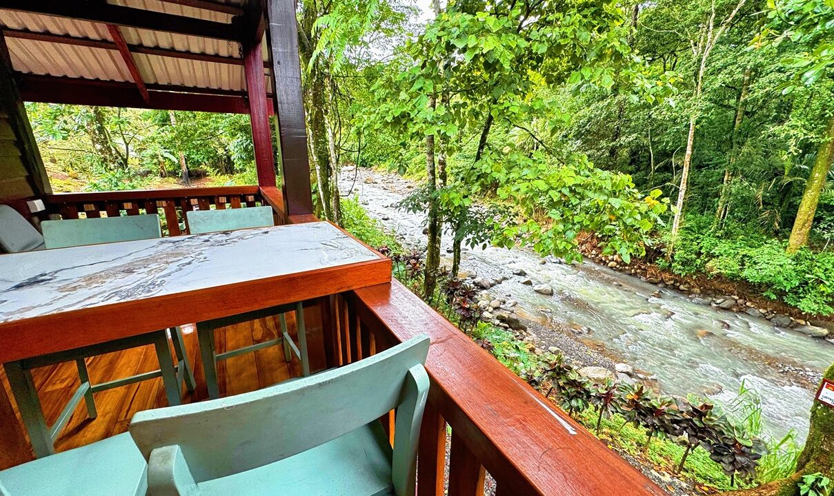 La Fortuna Costa Rica real estate with private river backyard. Two-story wooden house surrounded by lush nature perfect for Airbnb or family living.