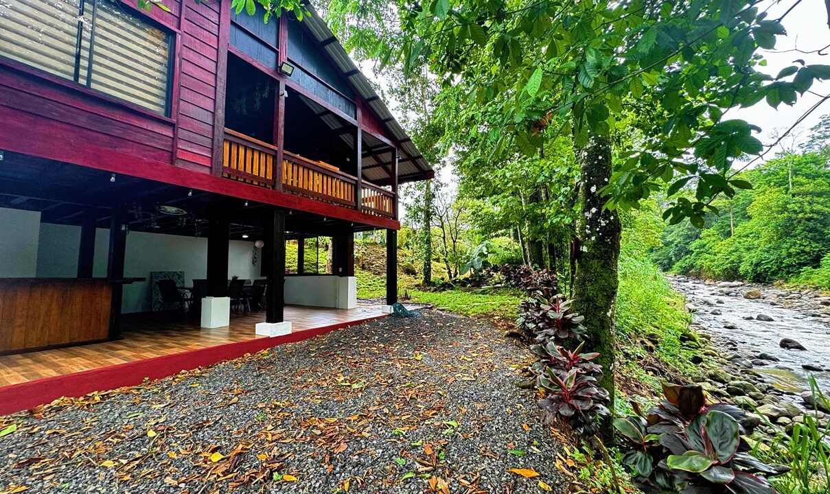 Spacious lower-level dining space in Costa Rica real estate listing near La Fortuna and Ciudad Quesada, surrounded by tropical greenery.